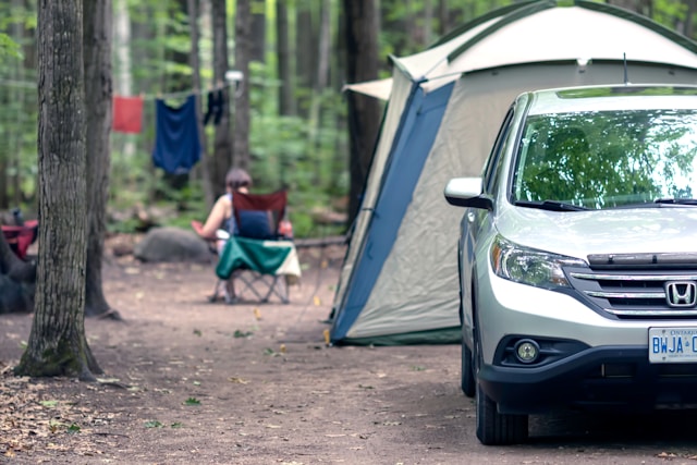 A tent alongside a car |